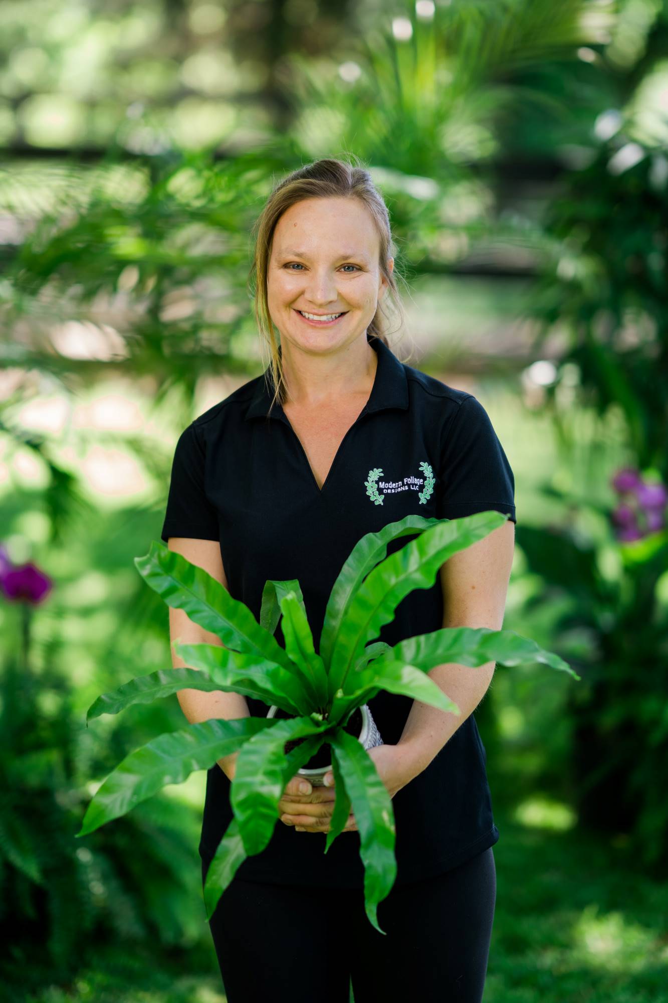 Photo of Nikki, owner of Modern Foliage, holding a medium sized flower pot